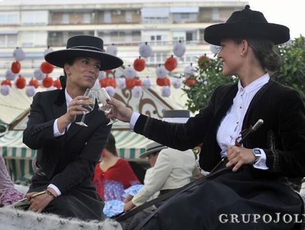 Dos j&oacute;venes jinetes brindan con una copa de manzanilla sobre su caballo.

Foto: Juan Carlos V&aacute;zquez