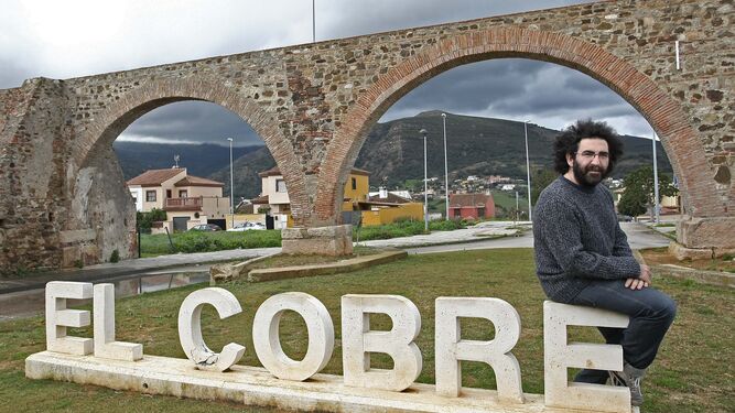 Antonio Romera, 'Chipi', sentado en las letras que anuncian El Cobre, su barriada, junto a los arcos.