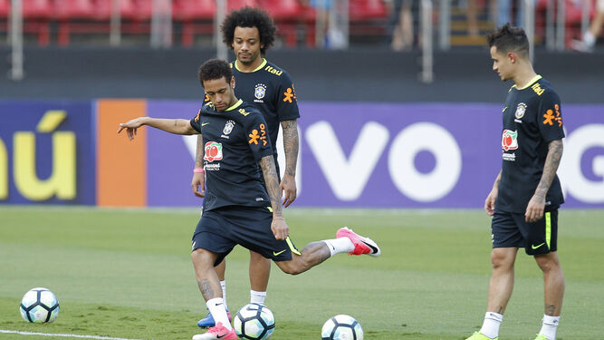 Neymar lanza a portería en presencia de Marcelo y Coutinho, en un entrenamiento en el Estadio Morumbi.
