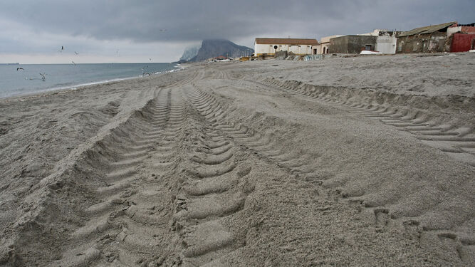 Marcas de neumáticos en la playa del Tonelero, junto a las viviendas.