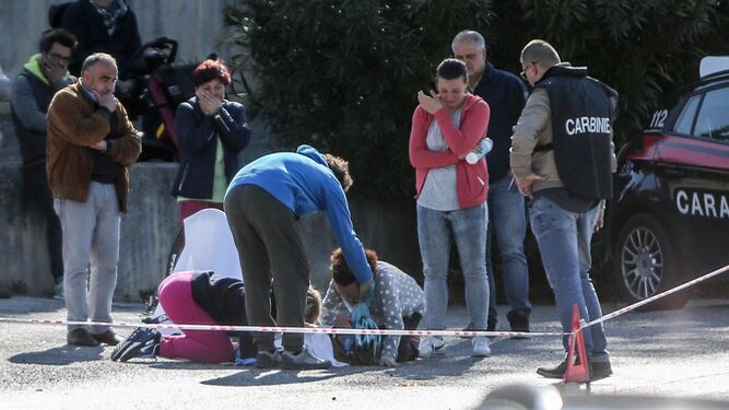 Varias personas, visiblemente afectadas, rodean el cuerpo sin vida de Michele Scarponi, atropellado en Filottrano.
