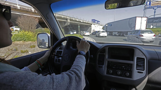 Una joven conduce un vehículo en una concurrida intersección.