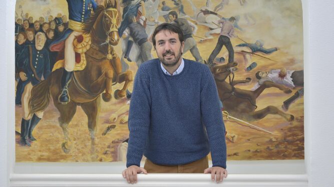 Francisco Ruiz delante de un cuadro de Manolo Ulloa.
