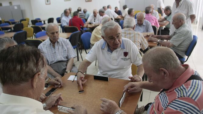 Pensionistas juegan al domino en la sede de una asociación.