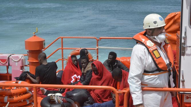 Miembros de Salvamento Marítimo trasladan al puerto de Tarifa a los migrantes rescatados.