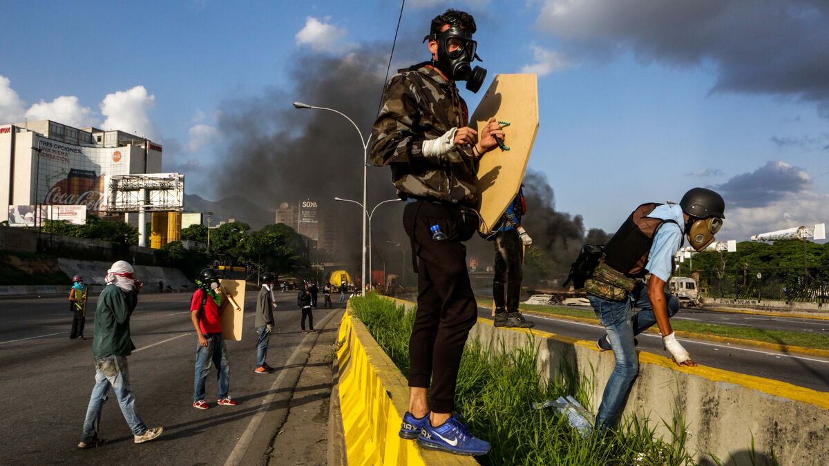 Varios opositores se protegen con máscaras en una marcha en Caracas.
