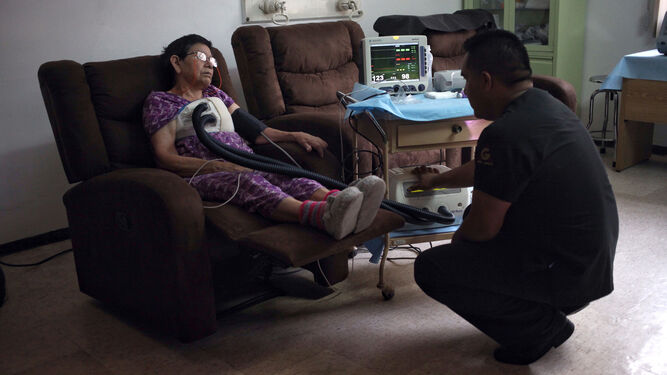 Una paciente recibe cuidados de su hijo en su domicilio de Ciudad de México.