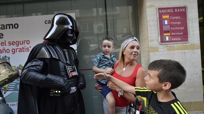 Un niño saluda a Darth Vader (personaje de 'Star Wars', en la calle Real, ayer por la tarde.