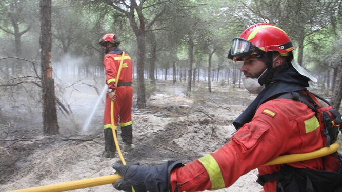 Miembros de la UME refrescan una de las zonas arrasadas por las llamas.