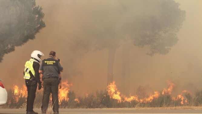 Dos efectivos de la Guardia Civil observan el alcance de las llamas.