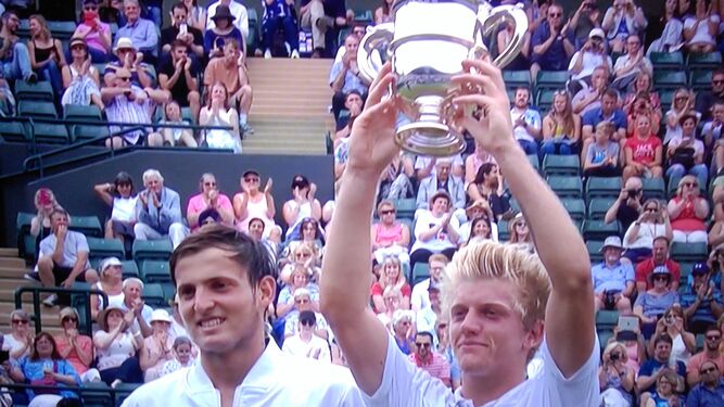 Alejandro Davidovich levanta el trofeo de campeón del torneo júnior de Wimbledon junto al argentino Axel Geller.