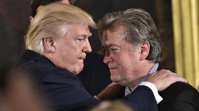 Donald Trump y Steve Bannon se saludan con un abrazo durante un acto.