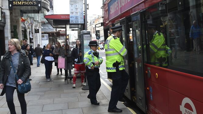 Policías de Londres se montan ayer en un autobús urbano.