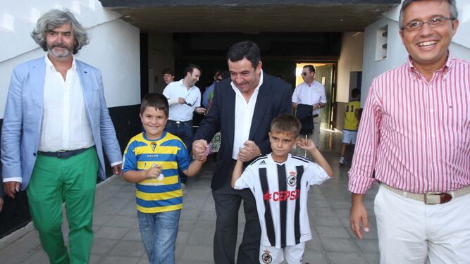 José Loaiza accede al Municipal antes de un Balona-Cádiz con dos niños vestidos con los colores de ambos clubes.