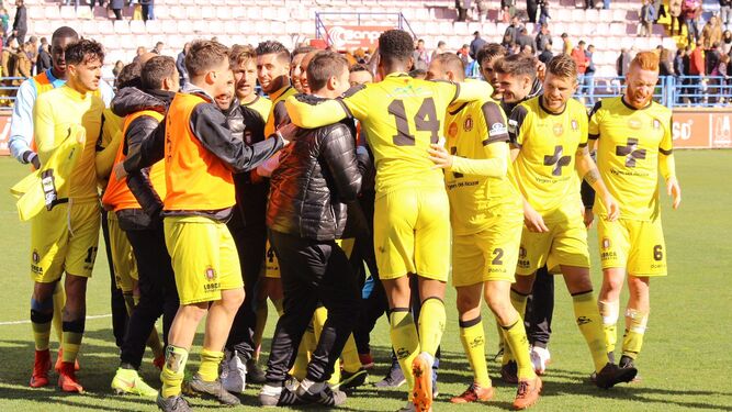 Jugadores y técnicos del Lorca Deportiva festejan su triunfo del pasado domingo en Almendralejo.