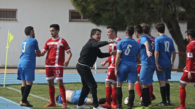 Bolli, técnico visitante, media en una discusión entre jugadores de uno y otro equipo.