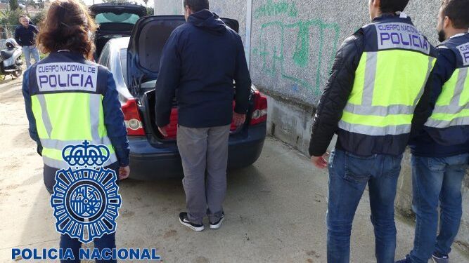 Agentes de la Policía Nacional, buscan en el interior del maletero de un coche.