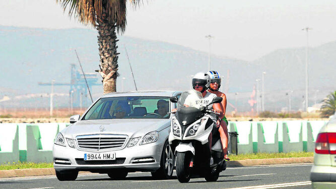 Dos personas circulan a bordo de una moto en la ciudad de La Línea.