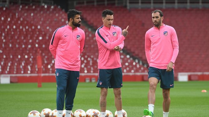 Giménez dialoga con Diego Costa y Godín en el entrenamiento de ayer en el Emirates.