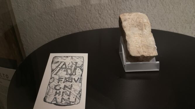 Fragmento de calendario romano expuesto en el Museo de Cádiz, junto con una lámina que clarifica su inscripción.