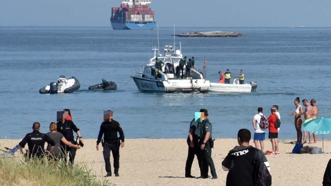 Policía Nacional y Guardia Civil trabajan en la playa. Al fondo, las embarcaciones implicadas en los hechos