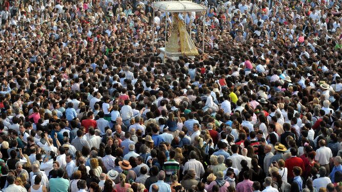 Un mar de personas acompañan a la Virgen del Rocío en su procesionar por la aldea almonteña.