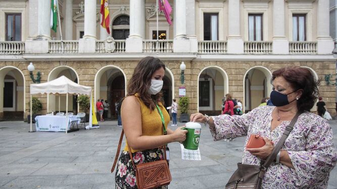 Una voluntaria de la AECC recoge el donativo de una señora en la plaza de San Juan de Dios de Cádiz.
