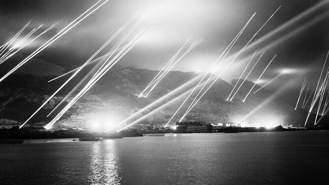 Reflectores surcan el cielo nocturno durante un simulacro de ataque aéreo en Gibraltar en 1942.
