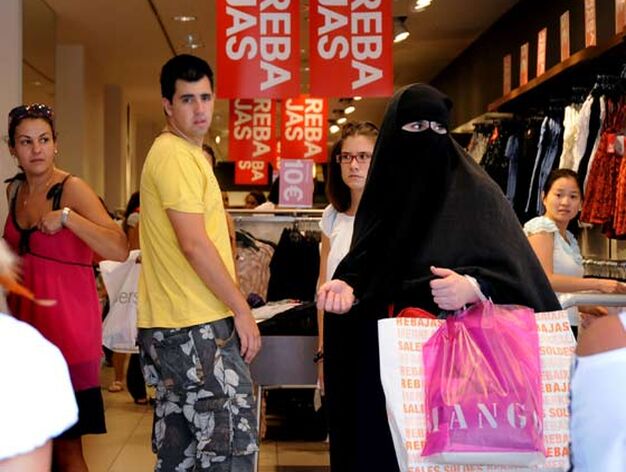 varias personas miran a una mujer cubierta con un burka que tambi&eacute;n aprovechaba las rebajas para hacer sus compras.

Foto: Juan Carlos V&aacute;zquez