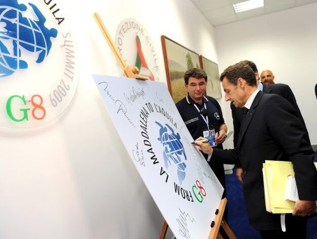 Sarkozy firma sobre el logo de la cumbre del G8.

Foto: EFE