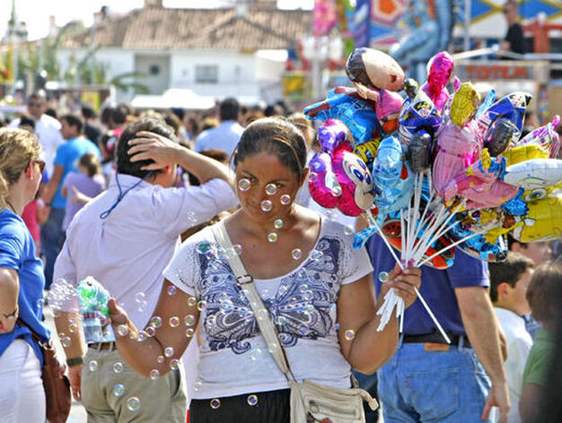 Mini regalos. Una se&ntilde;ora vendiendo globos y pistolas de pompas de jab&oacute;n, por la zona de las atracciones.

Foto: Pascual