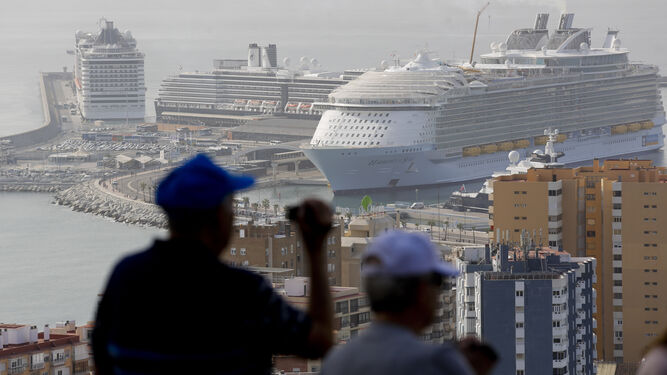 Varios turistas toman fotos de Málaga durante la escala simultánea de tres cruceros en su puerto.
