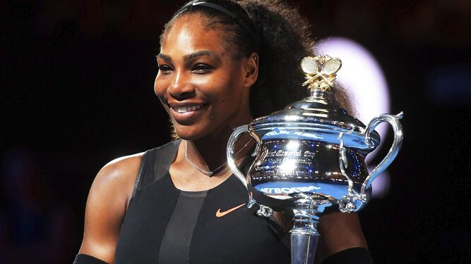 Serena Williams posa con un trofeo de ganadora.