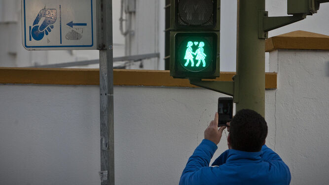 Un isleño fotografía con su teléfono móvil uno de los semáforos por la diversidad, en la avenida San Juan Bosco.
