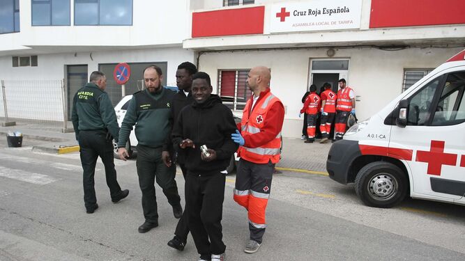 La Guardia Civil conduce a dos personas que fueron rescatadas en una embarcación cerca de Tarifa.