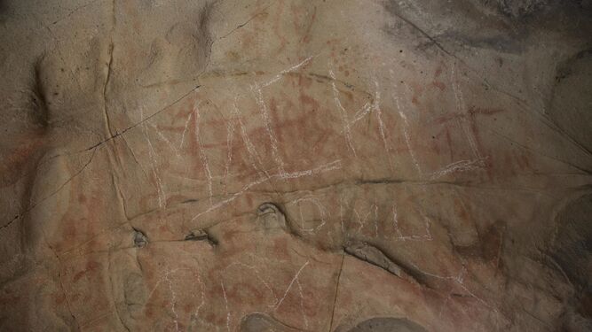 El panel principal, donde se observan los trazos blancos realizados aparentemente con una piedra arenisca sobre las pinturas rupestres.