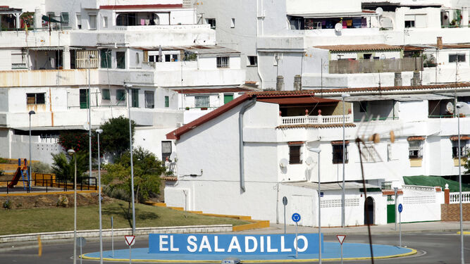 Las letras que dan la bienvenida a la barriada de El Saladillo, con los bloques de pisos detrás.