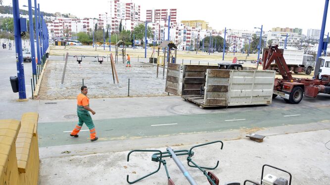 Operarios municipales desmontando el parque infantil de la feria.