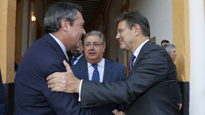 El alcalde de Sevilla, Juan Espadas, y Rafael Catalá se saludan en presencia de Juan Ignacio Zoido, ministro del Interior.