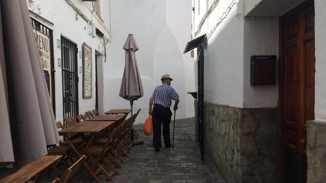 Un vecino pasea por una de las concurridas y estrechas calles del casco histórico tarifeño.