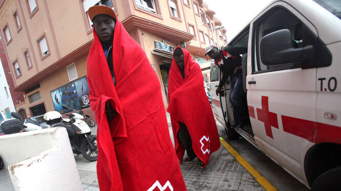 Dos migrantes subsaharianos son trasladados por Cruz Roja hasta el puesto de emergencias para ser atendidos tras su rescate.