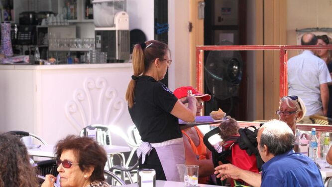 Una camarera atiende a los clientes de una céntrica terraza de La Línea.