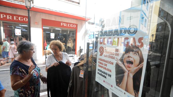 Dos mujeres echan un vistazo a la ropa de un perchero en el centro de La Línea, ayer.