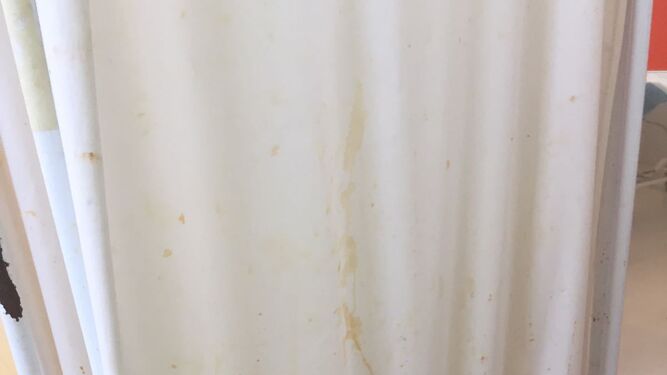 Detalle de una cortina de separación, sucia y oxidada.