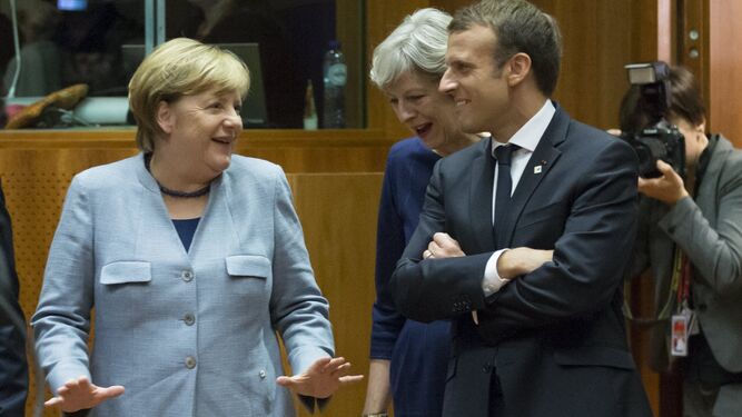 Merkel habla con May y Macron antes del comienzo de la cumbre del Consejo Europeo, ayer en Bruselas.