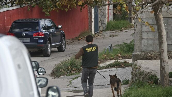 Un guardia civil camina ayer por Pelayo con un perro de detección de droga.