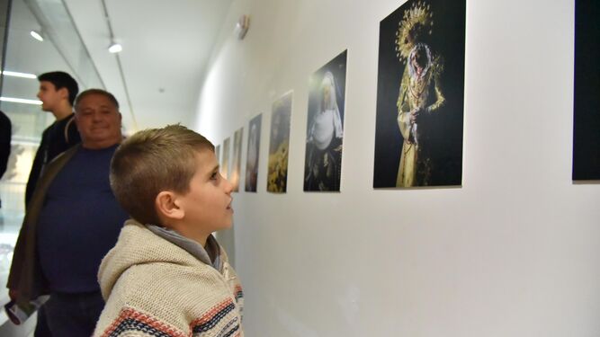 Un niño observa las fotografías de la exposición.