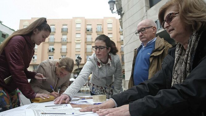 Carmen Gutiérrez, junto a sus padres, en la recogida de firmas en la Plaza de la Iglesia, ayer.
