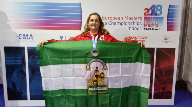 Teresa Boza posa con la bandera andaluza después de subir al podio.