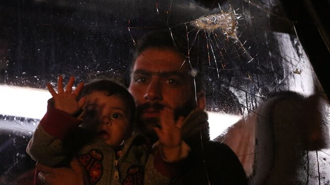 Un civil evacuado de Duma sostenía el miércoles a su bebé mientras observaba a través de la ventanilla de un autobús a su llegada a Alepo.